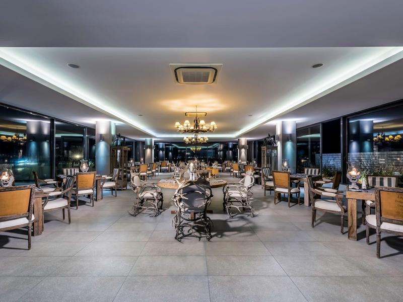 Modern, elegant dining room with large windows and stylish chairs in a hotel.