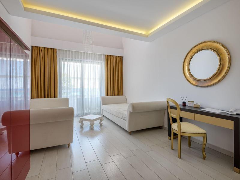 Modern living area with two sofas, desk, chair, and a large wall mirror.