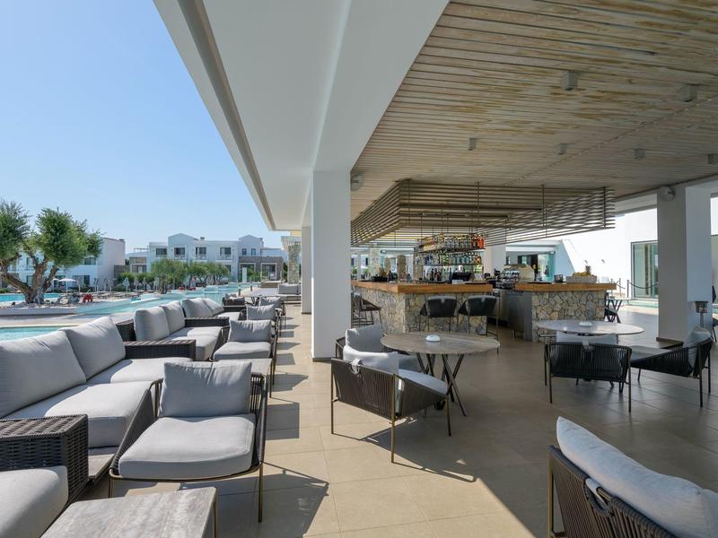 Modern outdoor hotel bar area with seating and pool view.