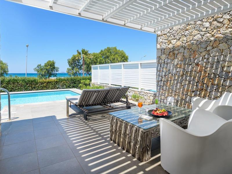 Modern outdoor area with seating and pool view under a covered patio.