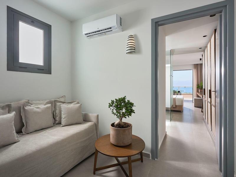 Soggiorno luminoso con divano, tavolino e vista sul corridoio con vista mare.