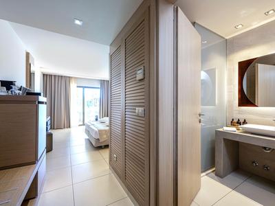 Modern hotel room with bed, closet, bathroom, and balcony view