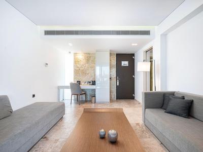 Modern hotel living area with two sofas and a simple wooden table