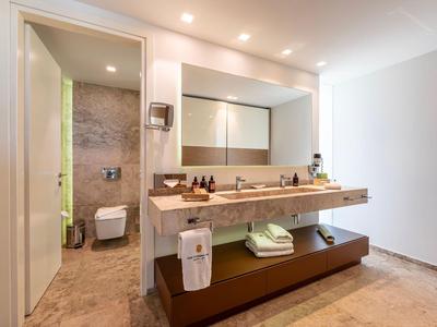 Modern hotel bathroom with open sink area and separate toilet.