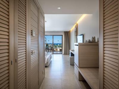 View through a hallway to a modern hotel room with sea view.