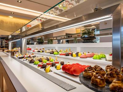 Modern buffet with a variety of fresh fruits and pastries in an elegant setting.