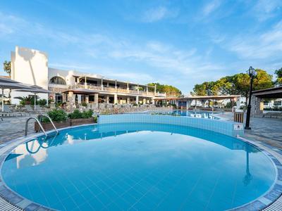 Piscina rotonda all'aperto dell'hotel con piastrelle blu che si affaccia su edifici e cielo azzurro