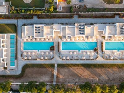 Vue aérienne d'un complexe hôtelier moderne avec trois piscines et transats