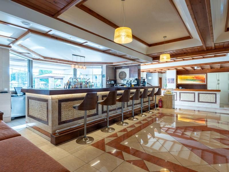 Bar d'hôtel élégante avec des tabourets hauts sombres et un design moderne en lumière du jour.