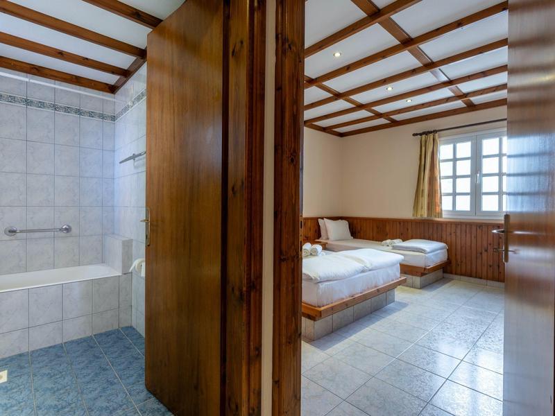 Chambre d'hôtel avec deux lits et salle de bain attenante avec baignoire