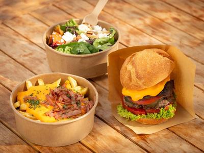 Burger vario, purè di patate ricco e insalata fresca su tavolo di legno.