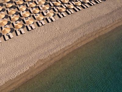 Vue aérienne d'une plage avec des transats et de l'eau claire.