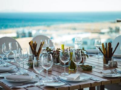 Table élégamment dressée avec verres à vin et couverts dans un restaurant avec vue sur la mer