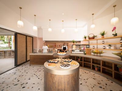 Hall d'hôtel moderne avec bar à café et pâtisseries sur une table ronde en bois