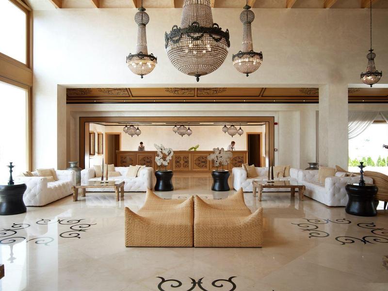 Lobby di hotel lussuoso con eleganti lampadari, soffitto in legno e aree salotto confortevoli