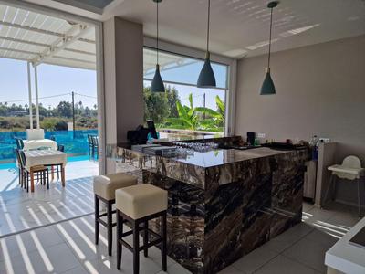 Moderne hotel lounge met donkere marmeren bar en uitzicht op buitenzwembad.