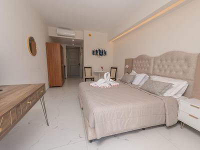 Jasny pokój hotelowy z podwójnym łóżkiem, biurkiem, klimatyzacją i nowoczesnym wystrojem.