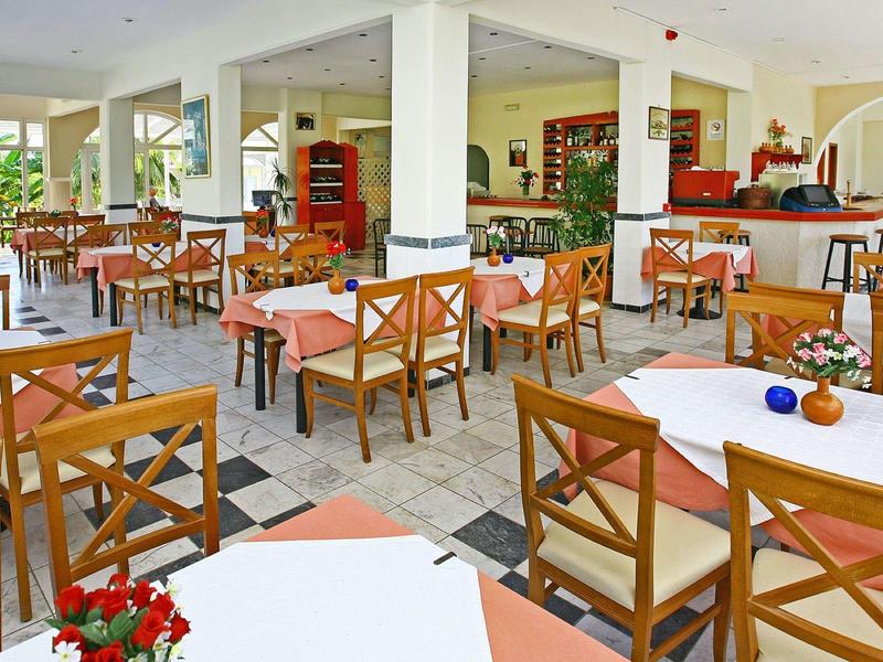 Jasna jadalnia z drewnianymi stołami i krzesłami w hotelu.