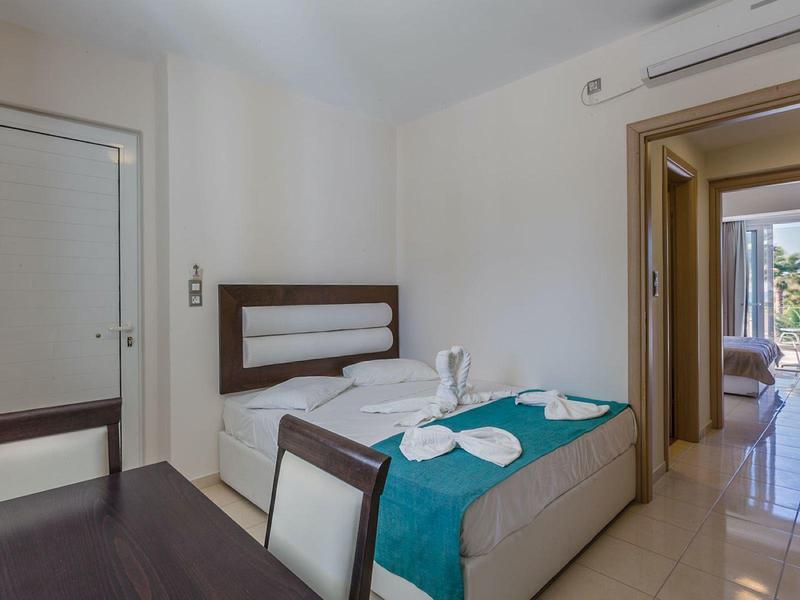 Nowoczesny pokój hotelowy z łóżkiem, krzesłami i widokiem na korytarz i balkon.