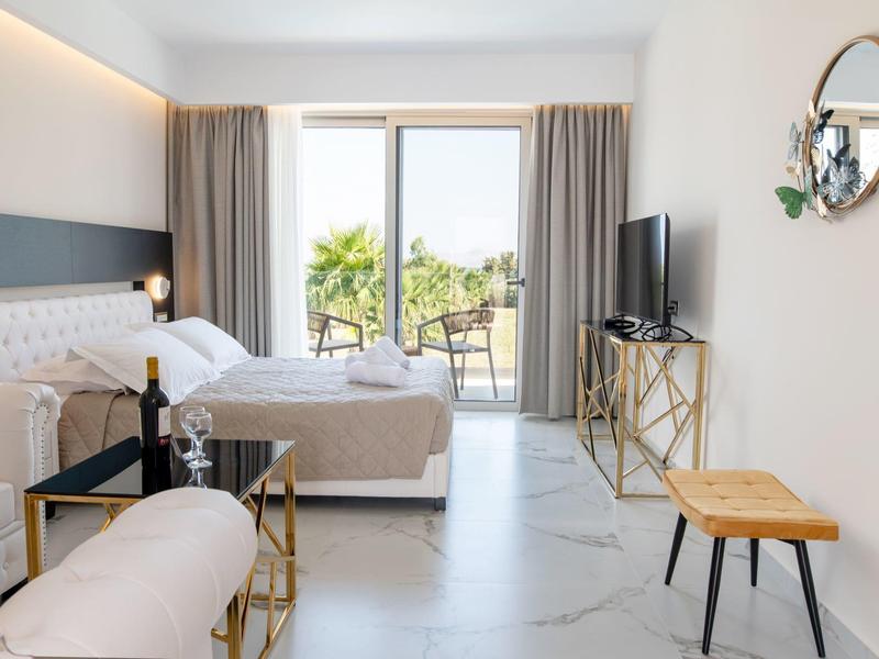 Nowoczesny pokój hotelowy z podwójnym łóżkiem, balkonem i widokiem na morze.