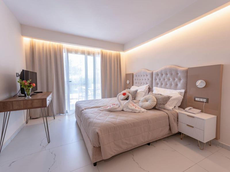 Nowoczesny pokój hotelowy z podwójnym łóżkiem, stolikami nocnymi, telewizorem i panoramicznym oknem