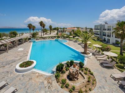 Moderner Hotelpool mit Liegestühlen, Palmen und Meerblick an einem sonnigen Tag.