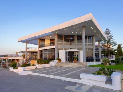 Modernes Hotelgebäude mit großer Terrasse und stufenförmigem Eingang bei klarem Himmel.
