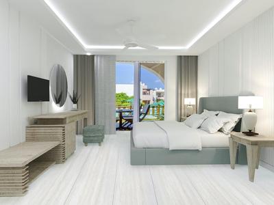 Moderna habitación de hotel luminosa con cama doble, TV, escritorio y balcón con vista al mar.