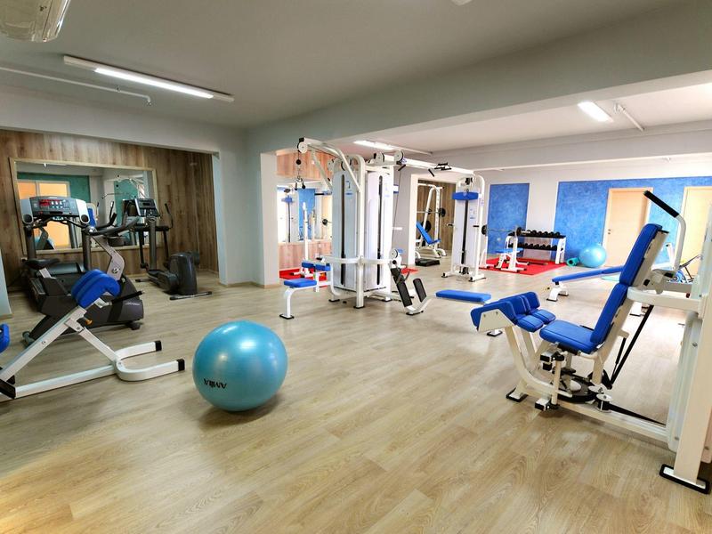 Gimnasio bien iluminado con equipos modernos y balón de gimnasia.