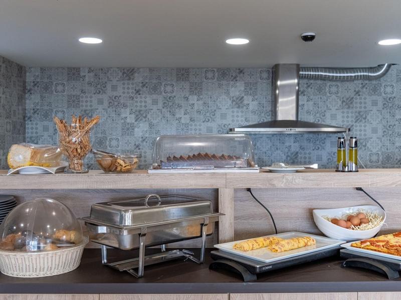 Bufet s různými teplými a studenými jídly v hotelovém pokoji.