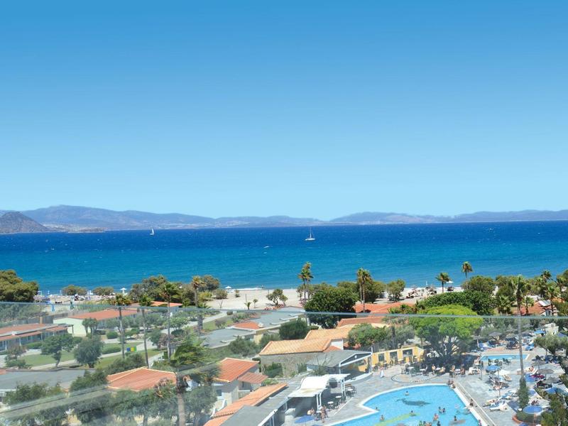 Panoramatický výhled na přímořské město s modrým mořem, bazénem a jasnou oblohou