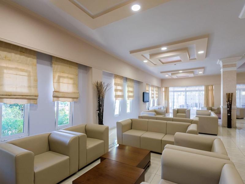 Moderne hotelkamer met lichte meubels, leren fauteuils en grote ramen.