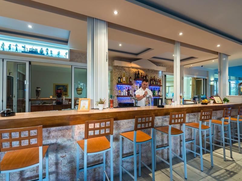 Moderne hotelbar met verlichte toonbank en hoge stoelen binnen in het hotel.