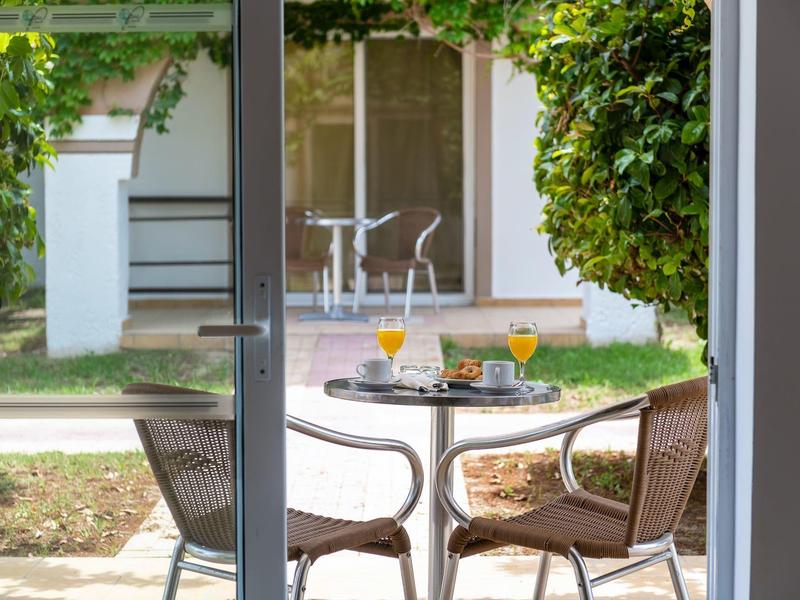 Terras met tafel, stoelen en drankjes voor een vakantiewoning met tuin