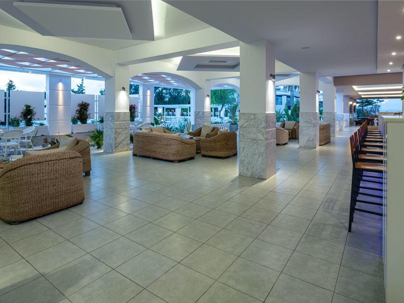 Lichte, modern ingerichte lounge met leren stoelen en barkrukken in een hotelhal.