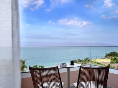 Balkon met twee stoelen en tafel met uitzicht op zee op een heldere dag.