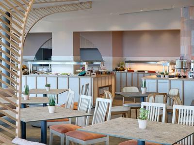 Modern ingerichte hotel eetruimte met houten stoelen en tafels.