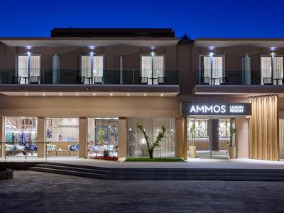 Modernes Hotelgebäude bei Nacht mit beleuchteter Fassade und Balkonen.