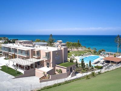 Hotel aan zee met zwembad, groene omgeving en heldere blauwe lucht