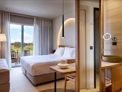 Modernes Hotelzimmer mit großem Bett, Balkon und natürlichem Licht.