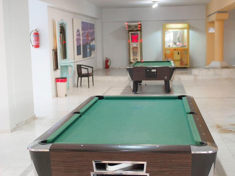 Stół bilardowy w jasnym, przestronnym pokoju gier z nowoczesnym oświetleniem.