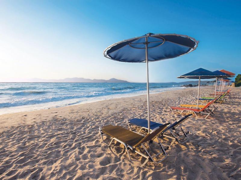 Pusta plaża z leżakami i parasolami pod czystym niebem.