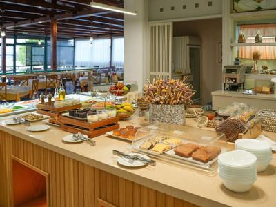 Area buffet con selezione per la colazione in un moderno ristorante d'hotel con grandi finestre.