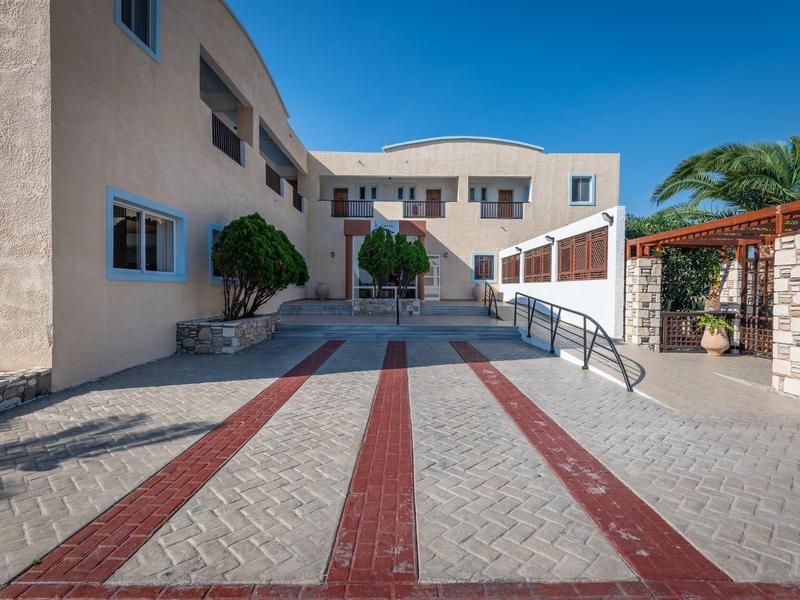 Moderner Gebäudekomplex mit heller Fassade, großem Eingangsbereich und klaren Linien unter blauem Himmel.