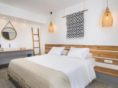 Chambre d'hôtel moderne avec lit double, accents en bois et décoration murale simple.