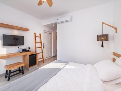 Chambre d'hôtel moderne et lumineuse avec lit double, bureau et climatisation.