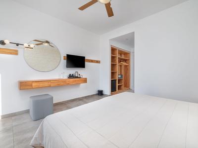 Chambre d'hôtel moderne et minimaliste avec lit double et bureau intégré.
