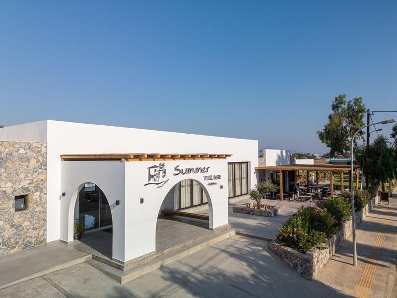 Ingresso di edificio bianco moderno con archi e pergolato in legno in una giornata di sole.