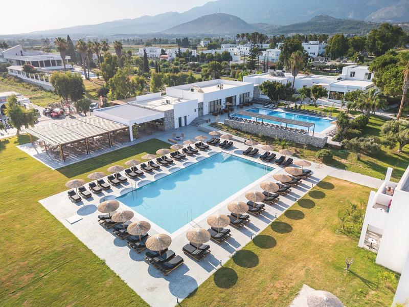Vista aerea di un resort con due piscine, lettini e prati verdi.