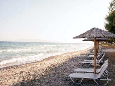 Spiaggia con lettini e ombrelloni sul mare calmo sotto un cielo sereno
